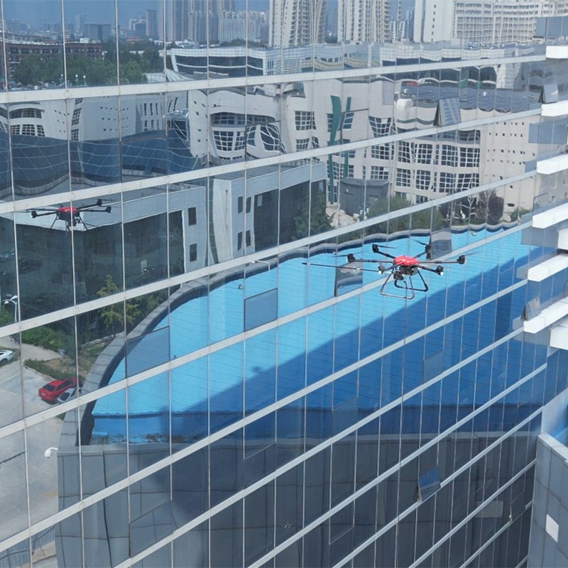 cleaning drone spraying water on glass building facade high rise drone cleaning system