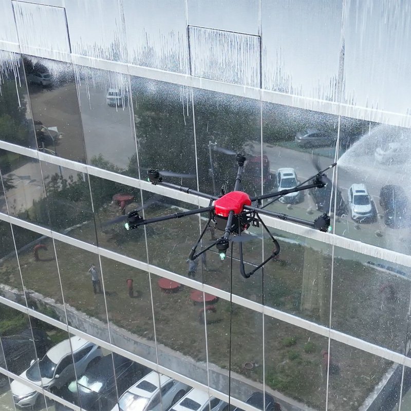 Red window cleaning drone performing high-rise glass facade cleaning for commercial building maintenance